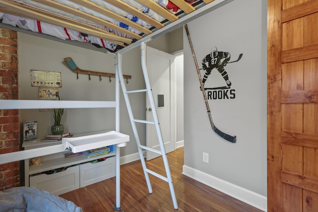 bedroom featuring wood finished floors and baseboards