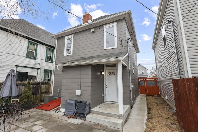 back of property with a patio area, fence, a chimney, and central AC unit