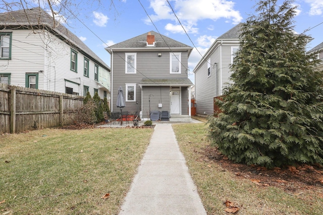 view of front of home with fence and a front lawn