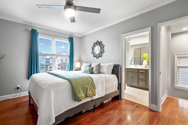 bedroom featuring crown molding, wood finished floors, connected bathroom, and baseboards