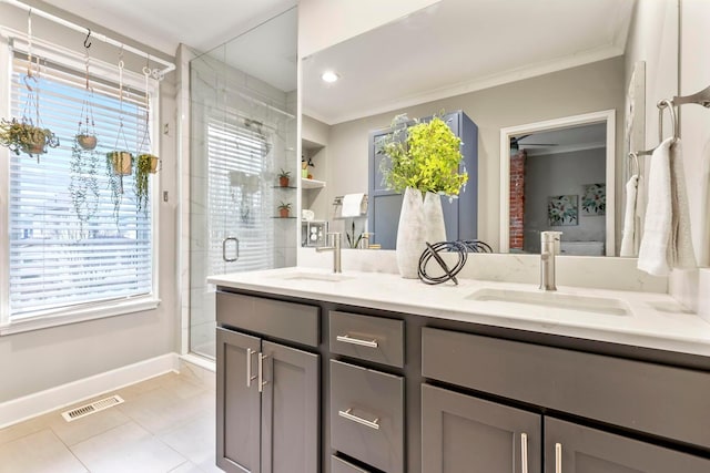 bathroom featuring a shower stall, visible vents, ornamental molding, and a sink