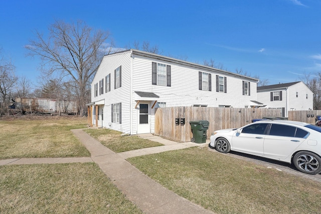 view of front of house with a front lawn and fence