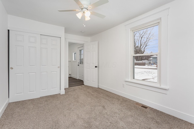 unfurnished bedroom with visible vents, baseboards, ceiling fan, carpet, and a closet