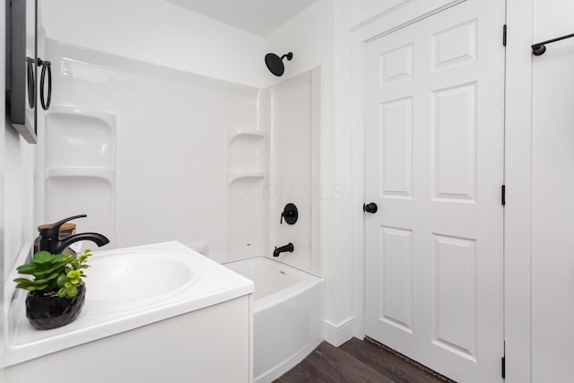 full bath featuring vanity, wood finished floors, and washtub / shower combination