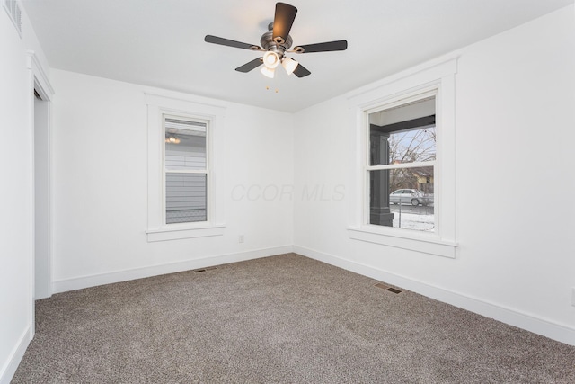 spare room featuring carpet, visible vents, and baseboards