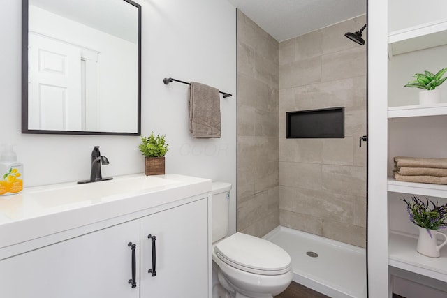 bathroom featuring a stall shower, vanity, and toilet