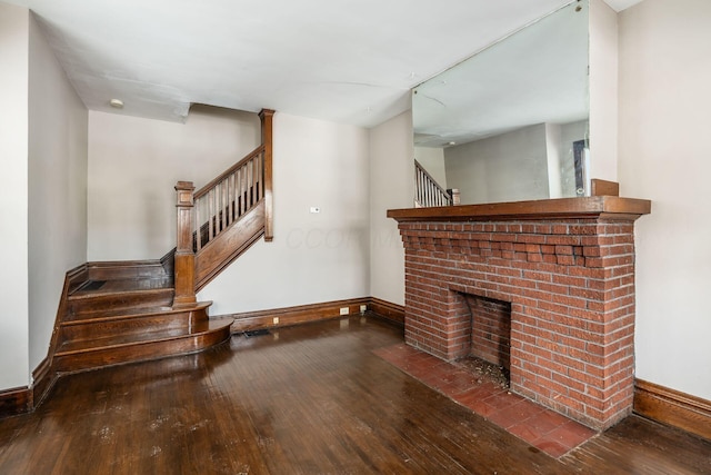 living area with stairs, a fireplace, wood finished floors, and baseboards