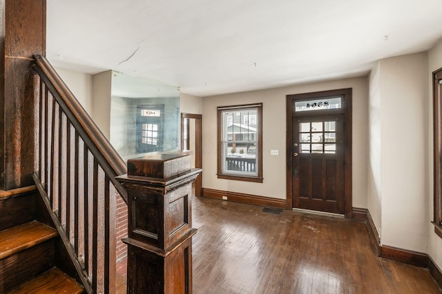 foyer featuring dark wood-type flooring, stairway, visible vents, and baseboards