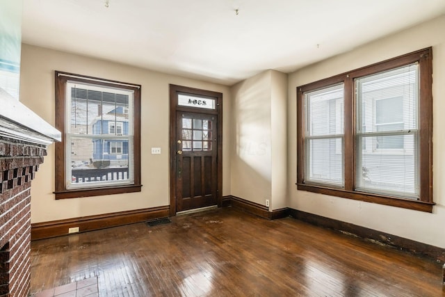 foyer featuring dark wood-type flooring, visible vents, and baseboards