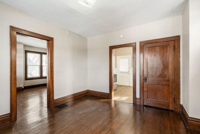 unfurnished room with visible vents, baseboards, and wood finished floors