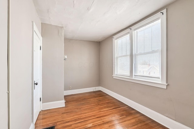 empty room featuring baseboards and wood finished floors