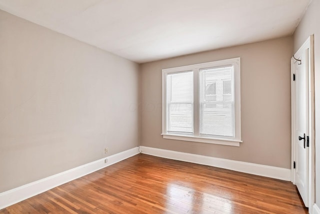 unfurnished room with baseboards and wood finished floors