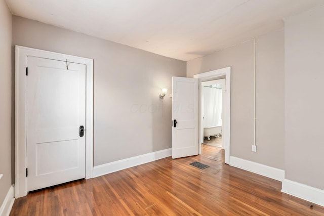 unfurnished bedroom with visible vents, baseboards, and wood finished floors