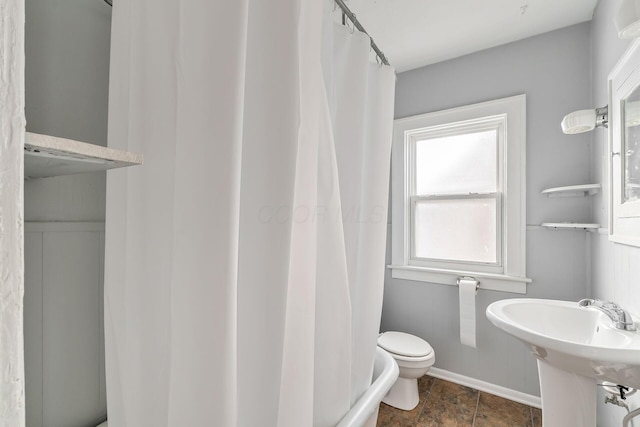 bathroom with toilet, a sink, and a shower with shower curtain