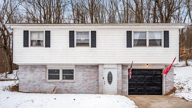 view of front of home with concrete driveway, brick siding, and an attached garage