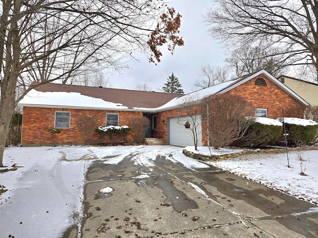 ranch-style house with a garage, brick siding, and driveway