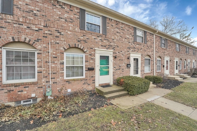 view of property with entry steps and brick siding