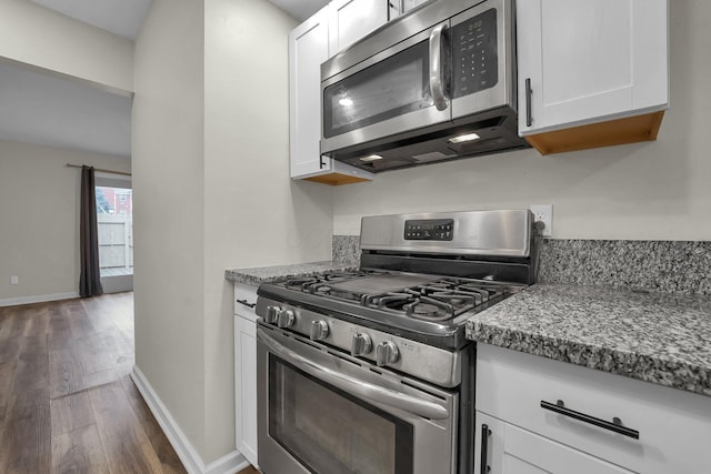 kitchen with stainless steel appliances, white cabinets, and dark wood-type flooring