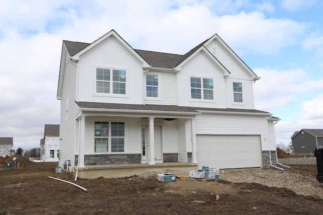 view of front of home with a porch, a shingled roof, an attached garage, board and batten siding, and stone siding