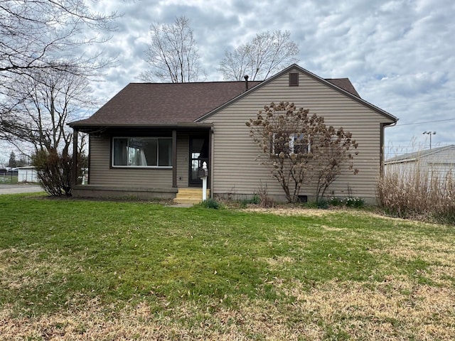 view of front of home featuring roof with shingles and a front yard