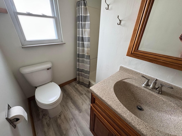 full bathroom featuring wood finished floors, toilet, vanity, baseboards, and a shower with shower curtain