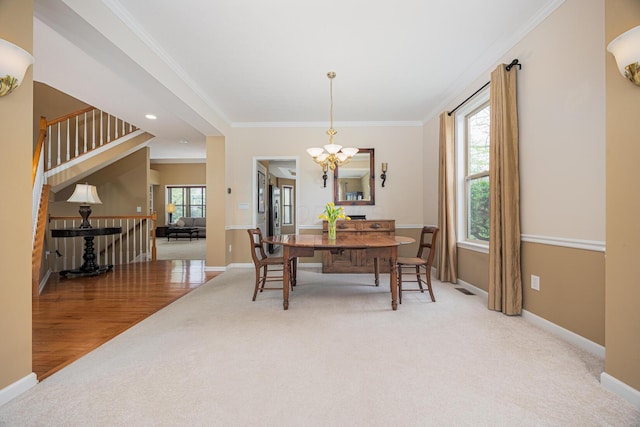 413 Ashmoore Cir E, Powell, OH 43065 - dining area with a notable chandelier, a wealth of natural light, crown molding, baseboards, and light colored carpet