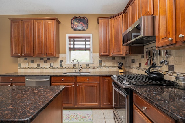413 Ashmoore Cir E, Powell, OH 43065 - kitchen with appliances with stainless steel finishes, dark stone counters, decorative backsplash, and a sink