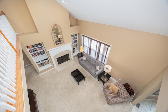 413 Ashmoore Cir E, Powell, OH 43065 - carpeted living area featuring a fireplace, built in features, lofted ceiling, and baseboards