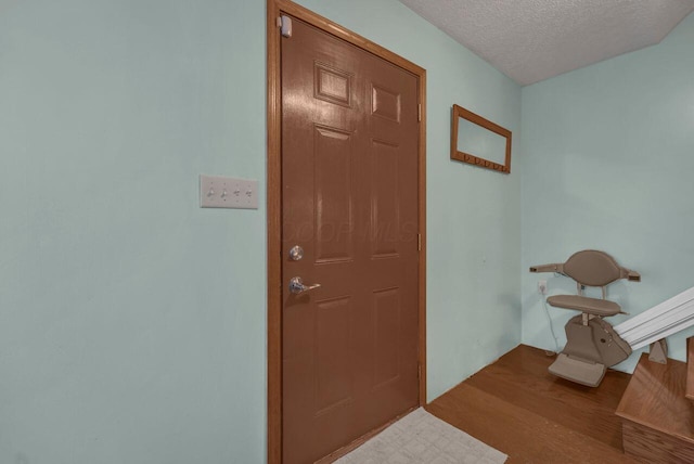 doorway featuring light wood-style floors and a textured ceiling