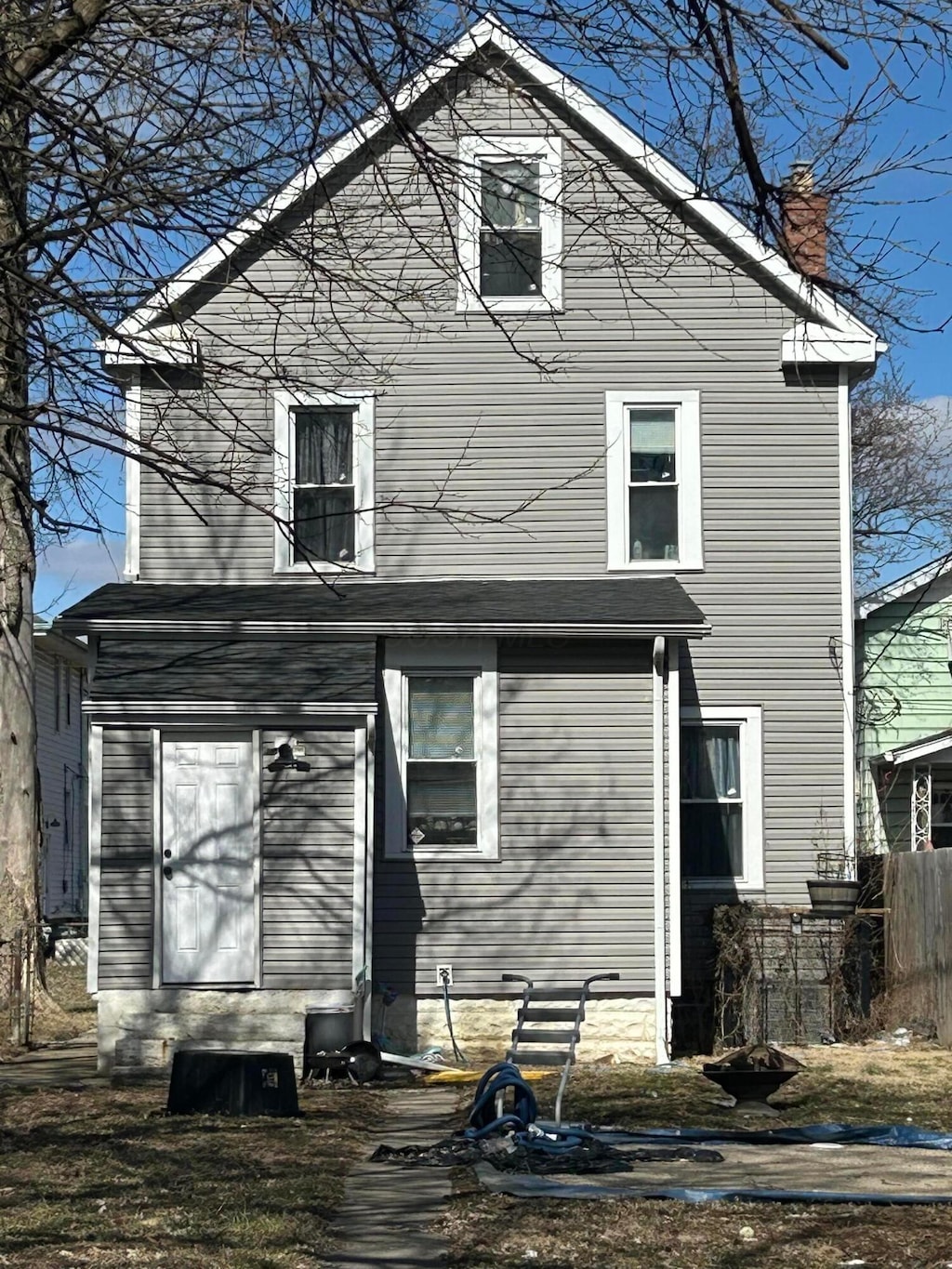 back of property with entry steps, a chimney, and fence