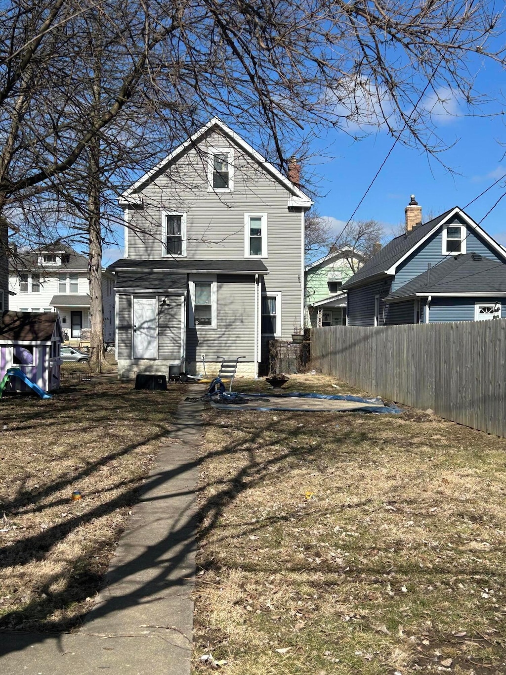 rear view of property featuring entry steps and fence