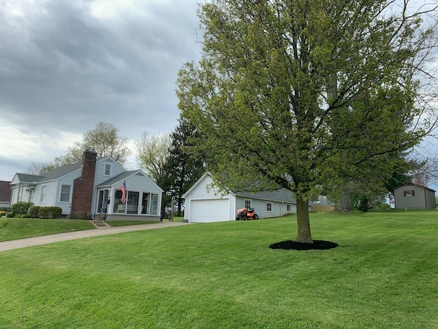 view of yard with a garage and concrete driveway