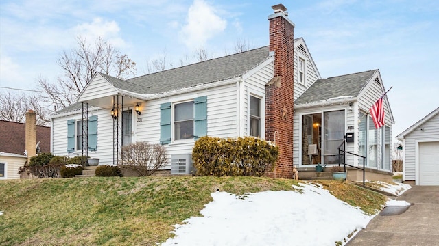 view of front of home with a garage, a shingled roof, a chimney, and a front lawn