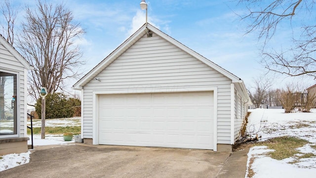 snow covered garage featuring a detached garage