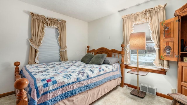 bedroom featuring visible vents, light carpet, and baseboards