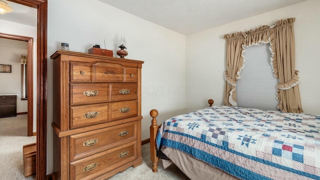 bedroom featuring light carpet and baseboards