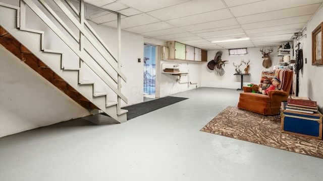 finished basement featuring stairway and a paneled ceiling