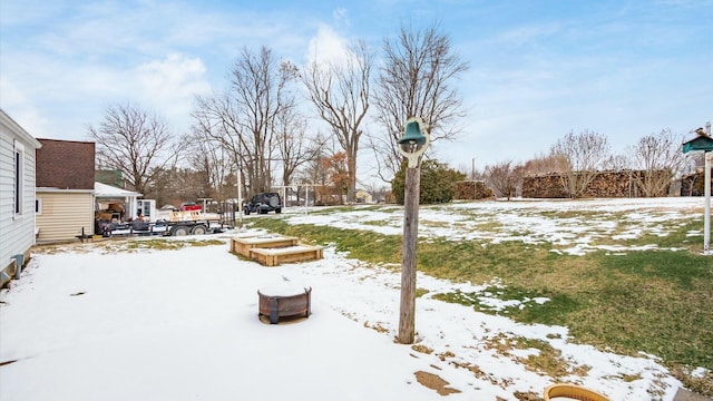 yard layered in snow with a vegetable garden