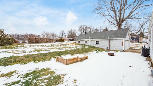 view of snow covered rear of property