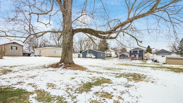 snowy yard featuring a residential view