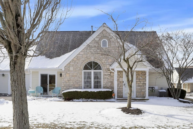 view of front facade featuring a shingled roof and central AC unit