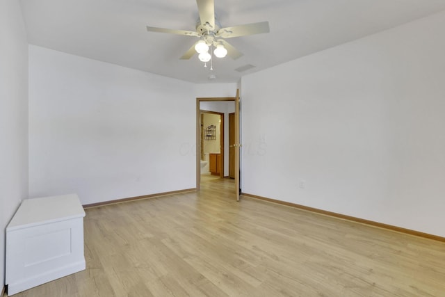 spare room featuring light wood finished floors, baseboards, and a ceiling fan