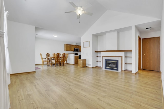 unfurnished living room featuring light wood finished floors, baseboards, a ceiling fan, a fireplace, and high vaulted ceiling