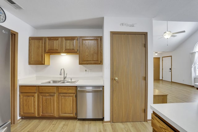 kitchen with appliances with stainless steel finishes, light countertops, a sink, and visible vents