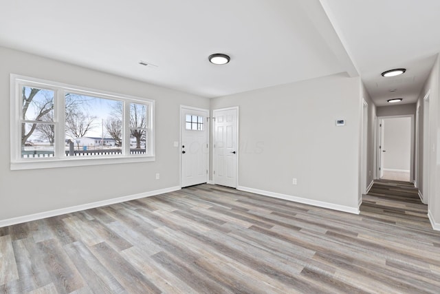 entrance foyer featuring light wood finished floors, visible vents, and baseboards