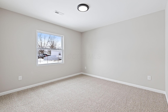 carpeted spare room with baseboards and visible vents