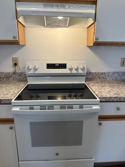 kitchen with light countertops, white electric stove, and extractor fan