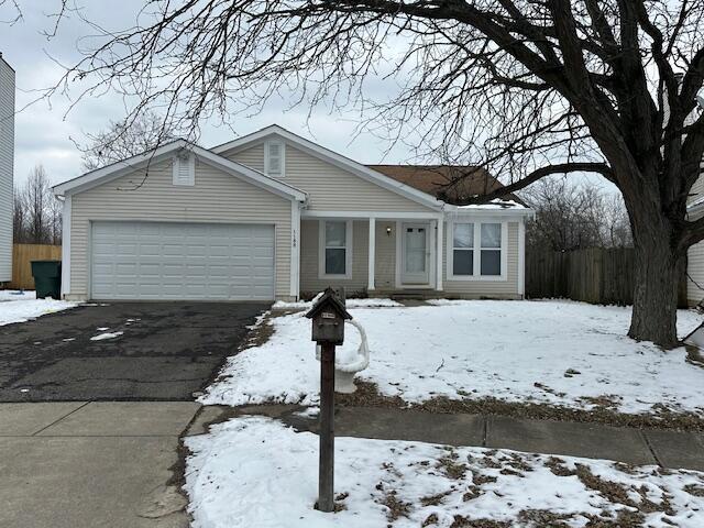 view of front of house featuring driveway, an attached garage, and fence