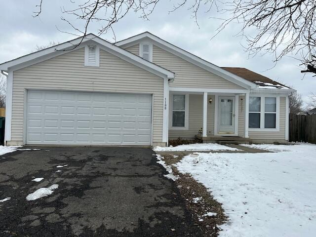 ranch-style home featuring an attached garage and aphalt driveway