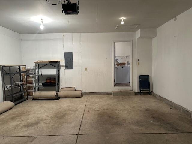 garage featuring washer / dryer, electric panel, and a garage door opener